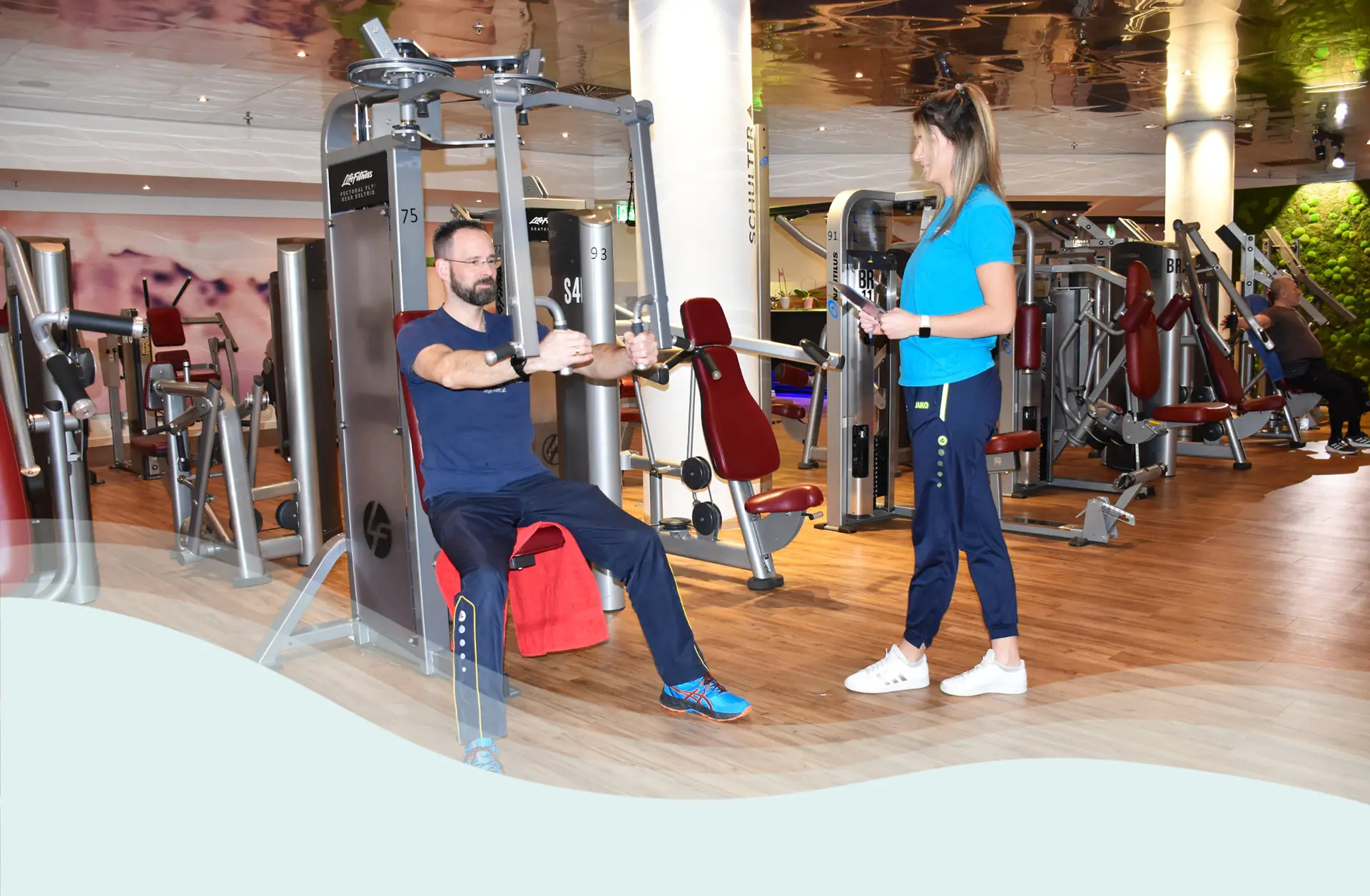 Mann wird beim Training von Mitarbeiter betreut
