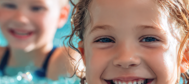 2 lachende Kinder beim Schwimmen